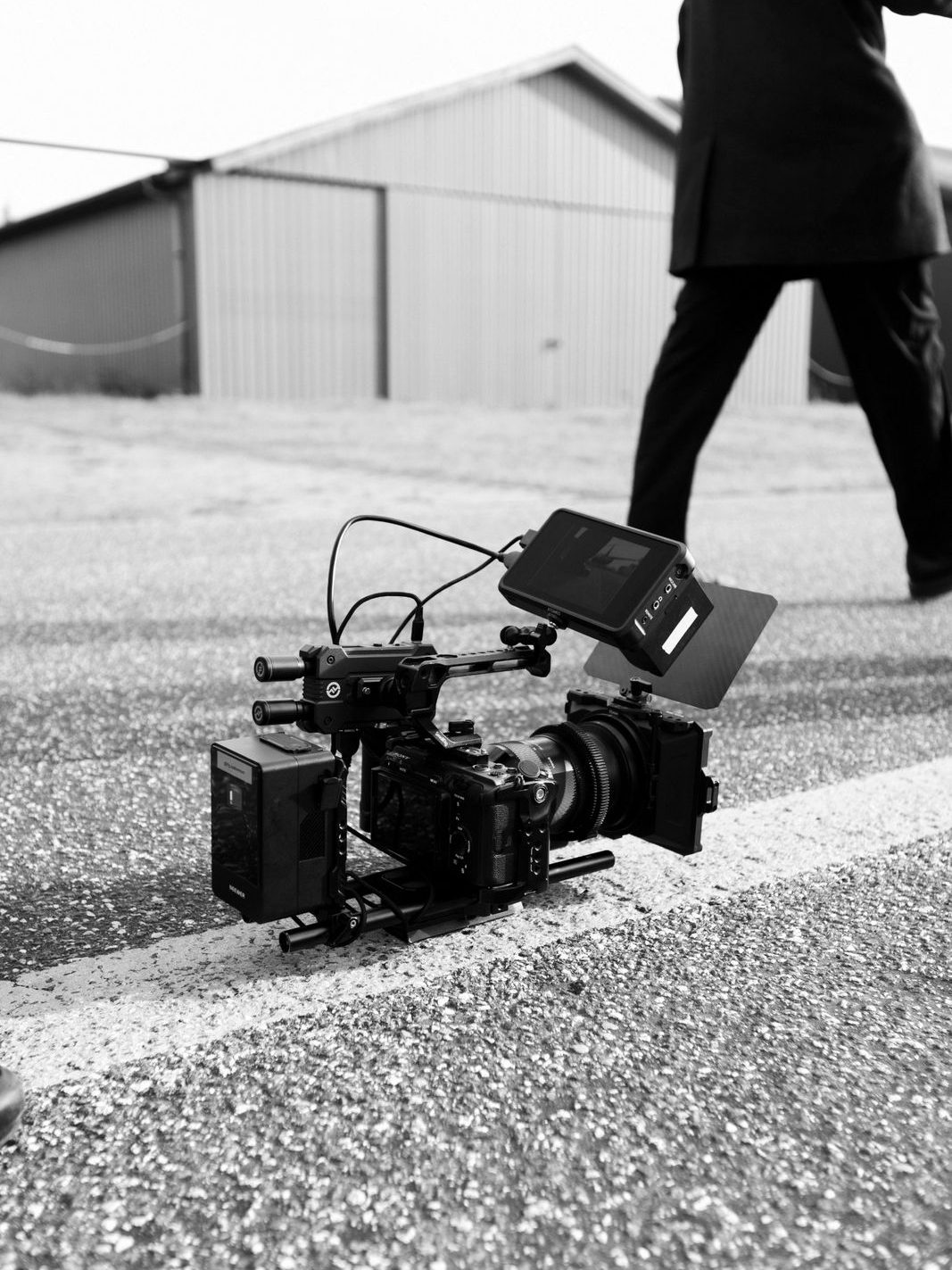 A camera rig resting on the tarmac as someone walks past
