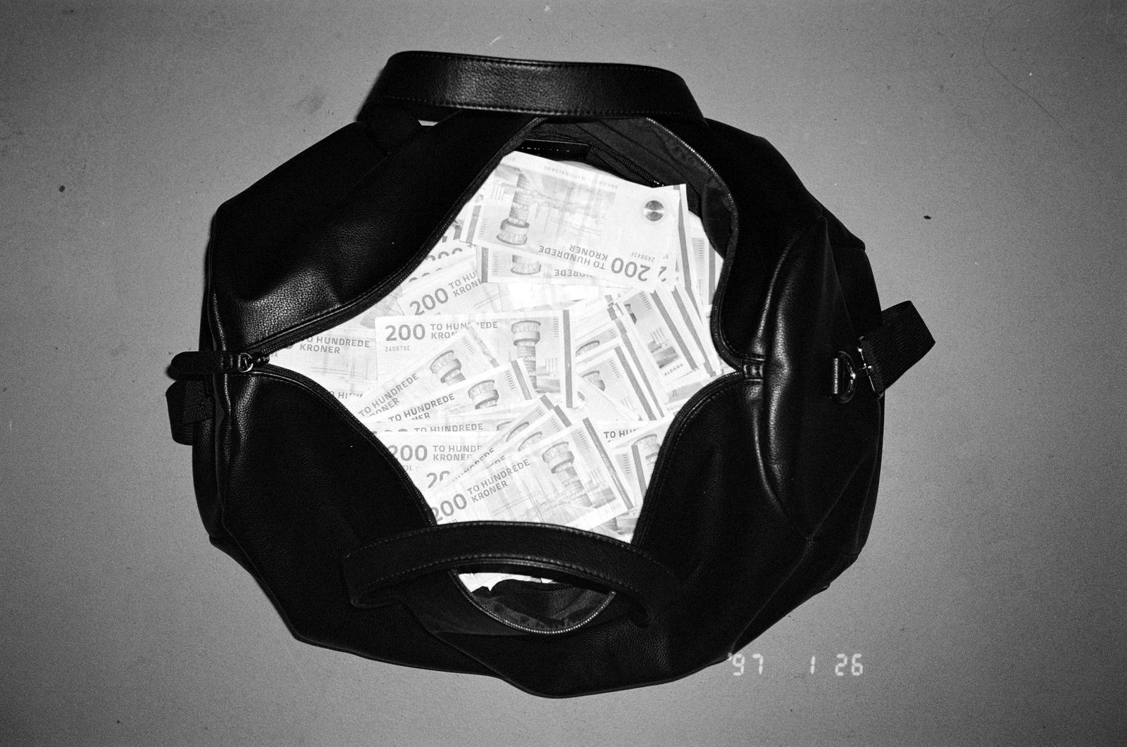An open leather bag full of banknotes